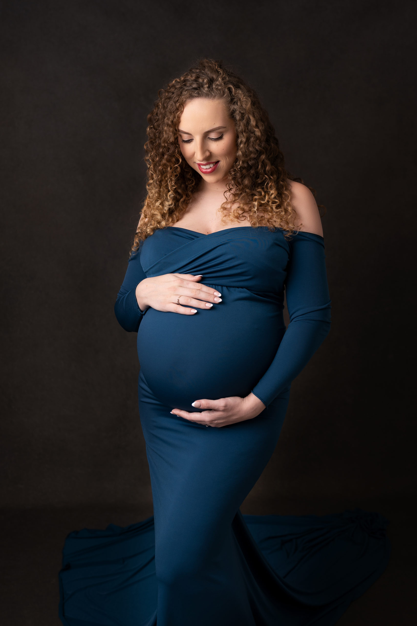 Pregnancy shoot on dark backdrop